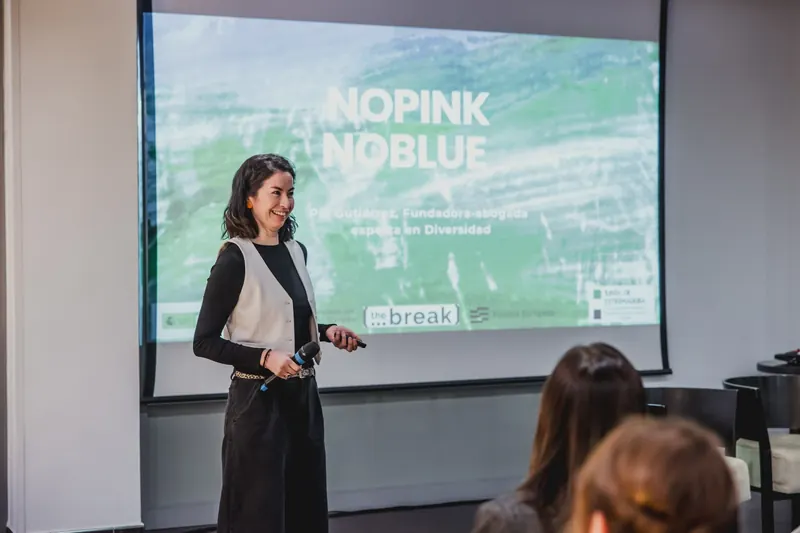 Pía Gutiérrez sonríe con un micrófono en la mano mientras presenta NOpink NOblue en el programa The Break